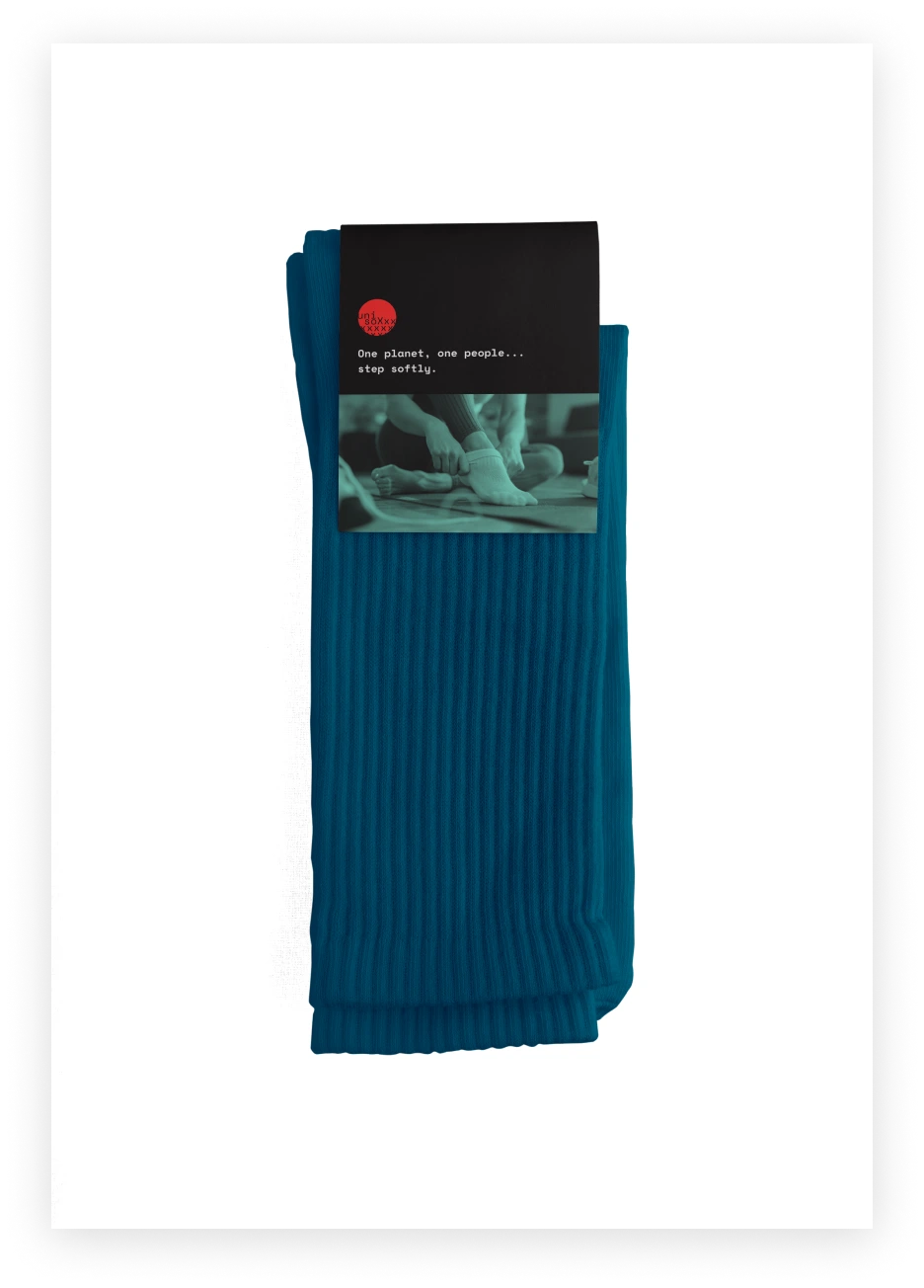 A pair of thick, dark blue, cotton socks folded with a paper band with brand label wrapped around them.